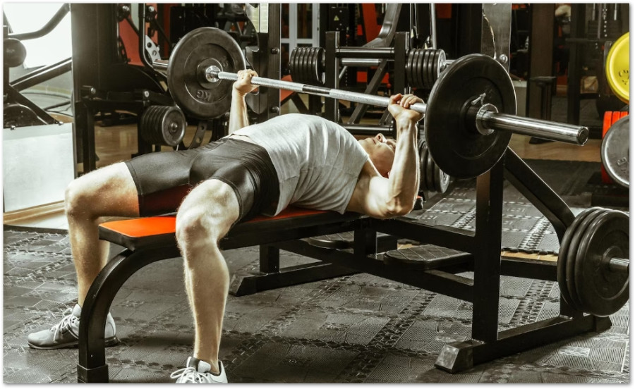 Person som utför bänkpress i ett gym